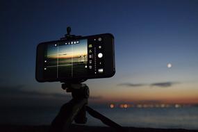 man takes photo on smartphone at night
