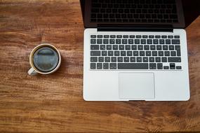 black coffee and laptop on wooden table