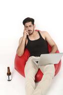 young man with beer in red chair