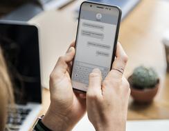 chat on a mobile phone screen in hands on a blurred background