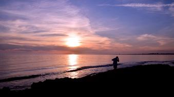 talking on a mobile phone at the seaside at dusk