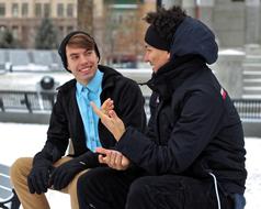 Two men, talking, while sitting on the bench, among the snow, in the winter