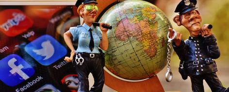 Figures of the policemen, Earth globe and colorful icons on the screen