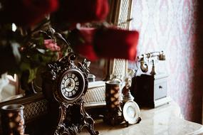 Close-up of the beautiful, colorful, vintage still life, with the old clock and telephone, in the house