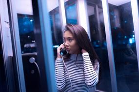young Girl talking on phone in booth