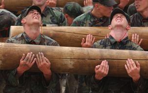 Teamwork, soldiers bearing heavy logs on training