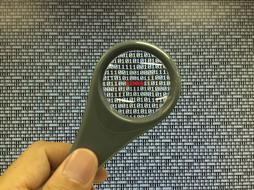 man holding a magnifying glass over passwords