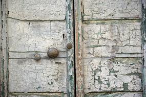 Close-up of the old, sagging, white and green door