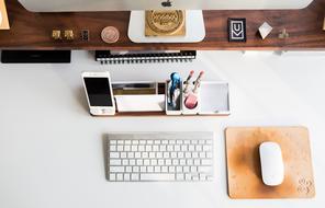 stationery, smartphone, monitor, keyboard and computer mouse on the desktop