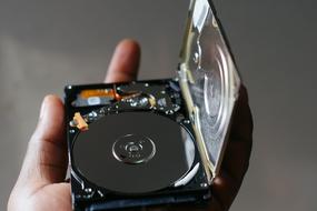 Computer Hard Disk in hand close-up on blurred background