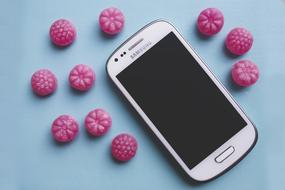 pink candy and samsung galaxy on the table