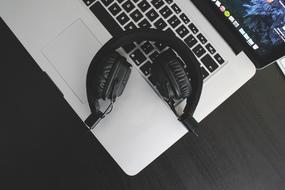 Black headphones, on the white and black laptop, on the table