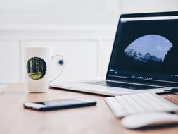 Laptop Computer, smartphone and mug on desk