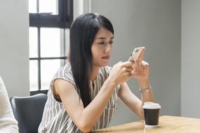 young asian girl with mobile phone during a break