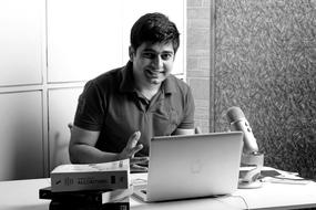 Black and white photo of the man, coding on the laptop