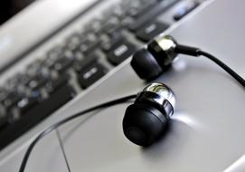 Close-up of the black, shiny headphones on the grey laptop