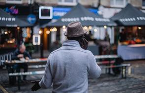 man with mobile phone in city square in blurred background