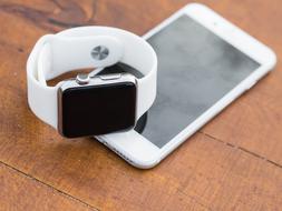 Iphone Iwatch on a wooden surface close-up