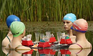 Mannequins in colorful swimming goggles and caps, with table, in the water