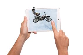 3d figure of a rider on the bike, in jump, in the tablet, in the hands of a person