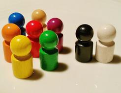 Shiny and colorful play stones, with the shadows, on the cream surface