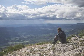 a man with a phone at the top of a mountain