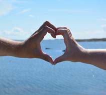 heart from hands on a background of blue sea