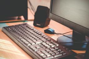 silver Computer Keyboard in front of monitor