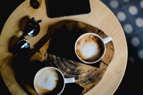 two cups of coffee and sunglasses on the coffee table
