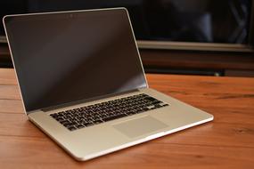 Shiny Mackbook laptop, on the brown wooden table