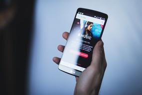 smartphone with music in man's hand