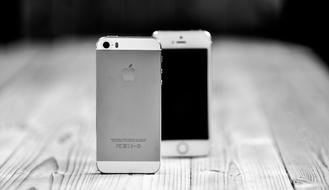 black and white photo of a couple of mobile phones on the table