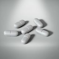 six antibiotic pills on a white background