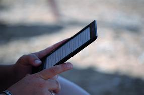 Person, reading text in the ebook, at blurred background