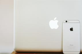 photo of macbook and white iphone