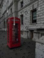 Beautiful red phone booth in rain, view through the window, in London, England