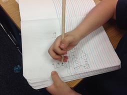 student draws diagrams in a notebook