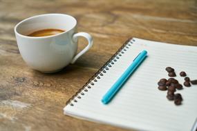 white cup of black coffee and notepad