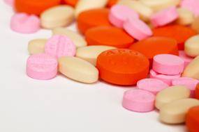 pink, orange and white pills on the table