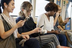 young girls with digital devices in train