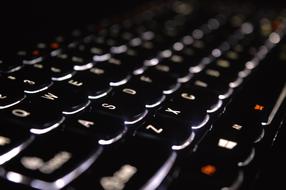 Beautiful, black, white and orange keyboard of laptop, with lighting