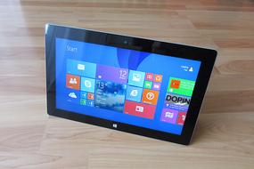 Black Microsoft tablet with Windows 8 on the wooden surface