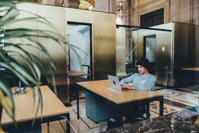 young Man wearing black hat works with Laptop