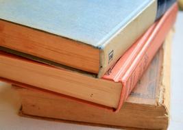 Stack of the colorful, old, shiny books, in light