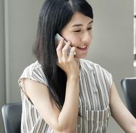 asian girl in striped blouse talking on smartphone