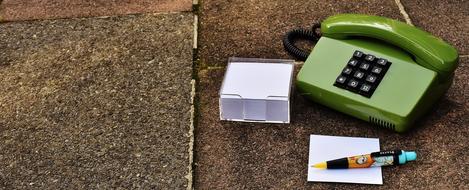 pen with notes lie near the old green phone