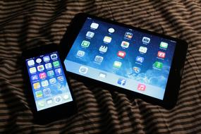 tablet and smartphone on the bed