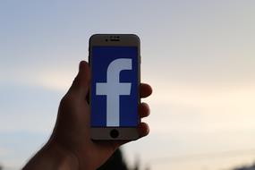 facebook logo on smartphone screen in hand