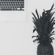 Black and white photo of the beautiful pineapple, near the laptop