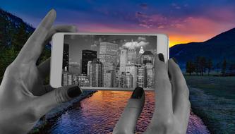 photo of a city with skyscrapers on a smartphone in the hands of a man